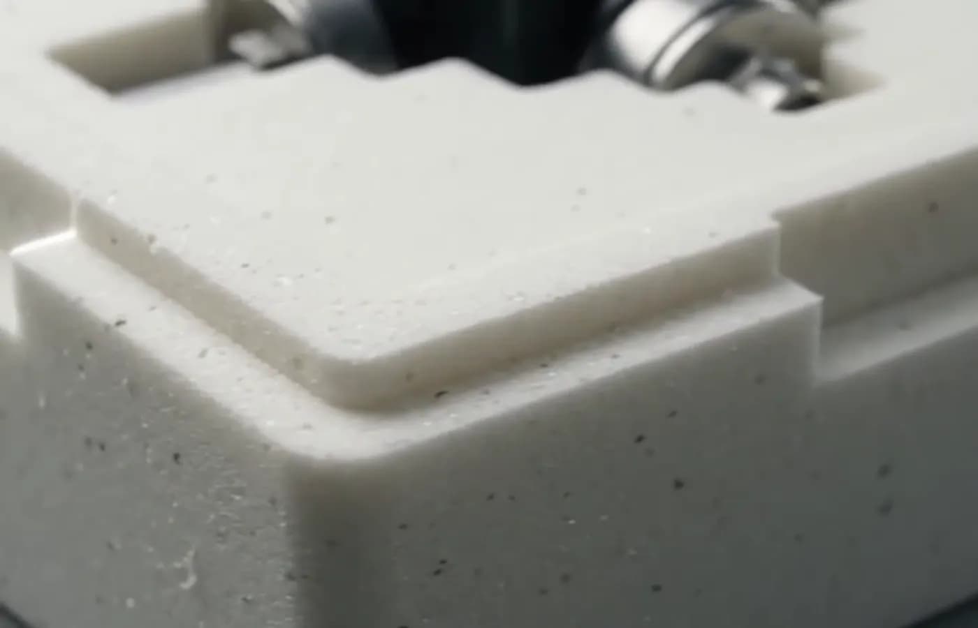 Corner and edge of a dense PU foam cushion that absorbs impact in a drop test